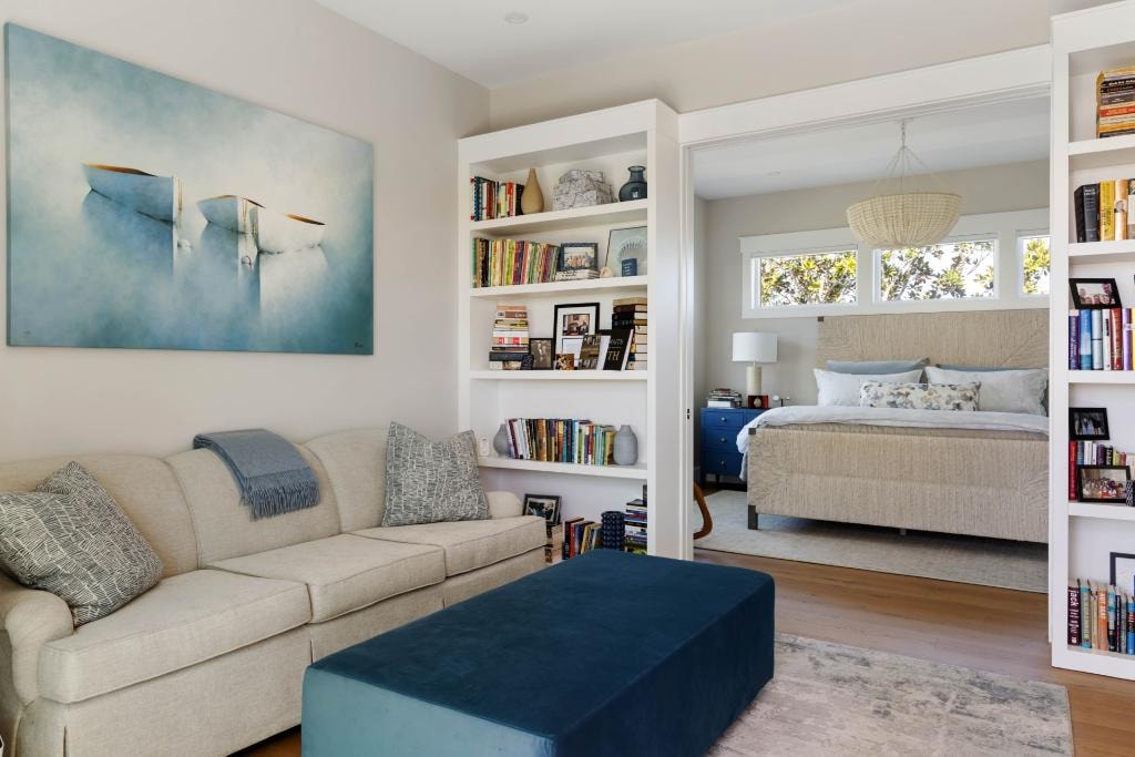 Living room with built-in bookshelves opening to master bedroom suite